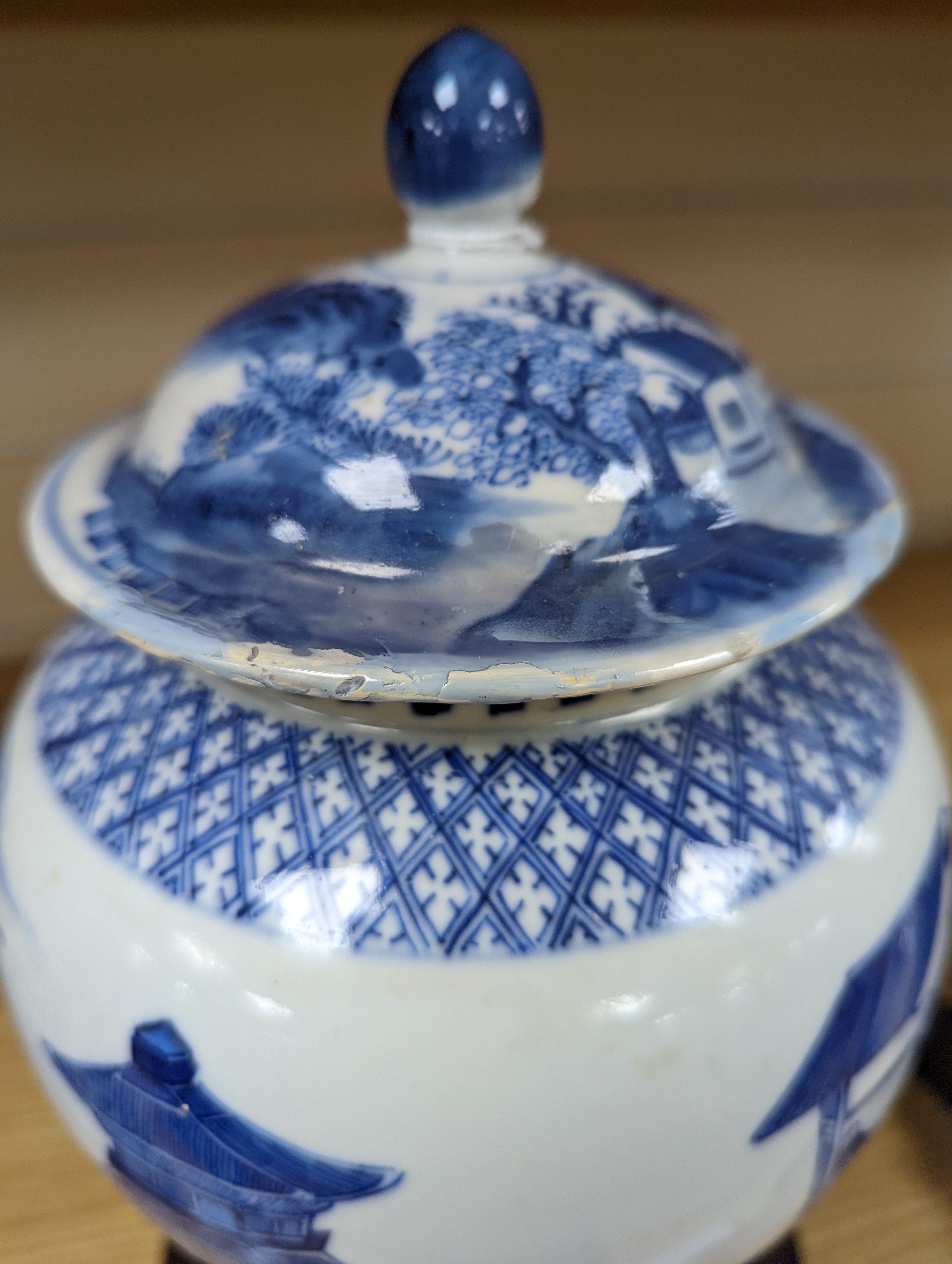 A late 19th / early 20th century Chinese blue and white landscape jar and cover, wood stand 30cm total height